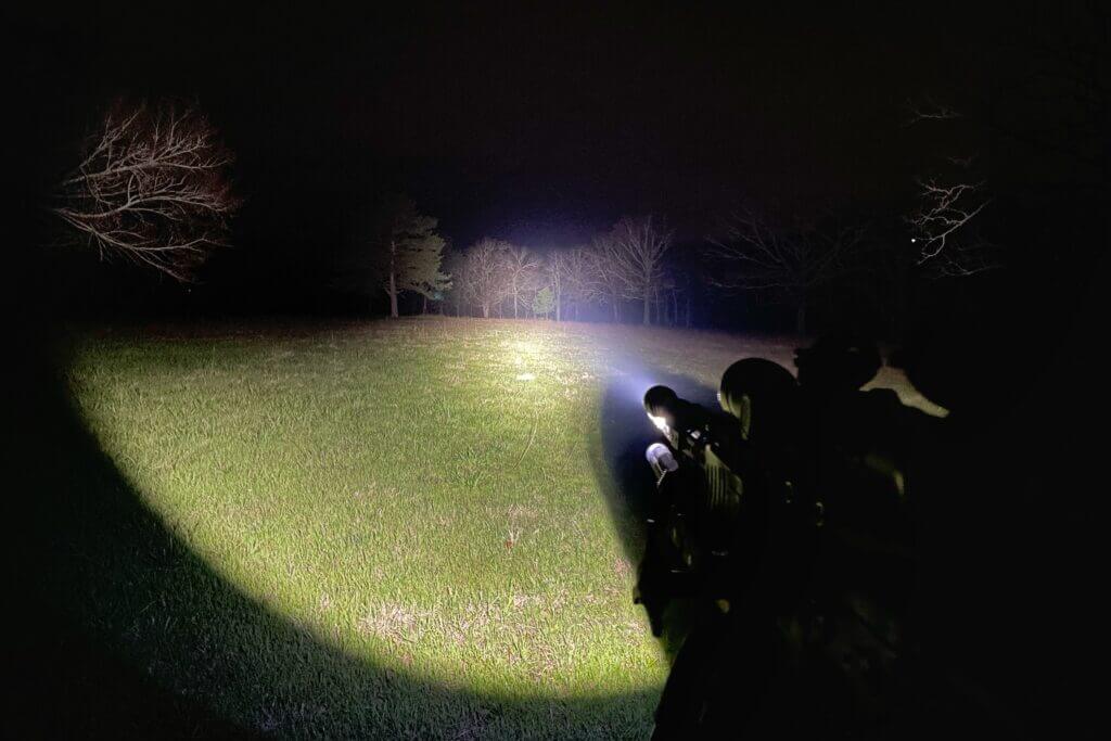 Strong light beam from end of rifle at the dead of night