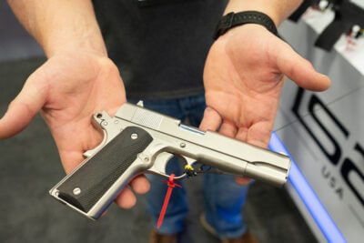 Two hands holding a Tisas 1911 pistol.