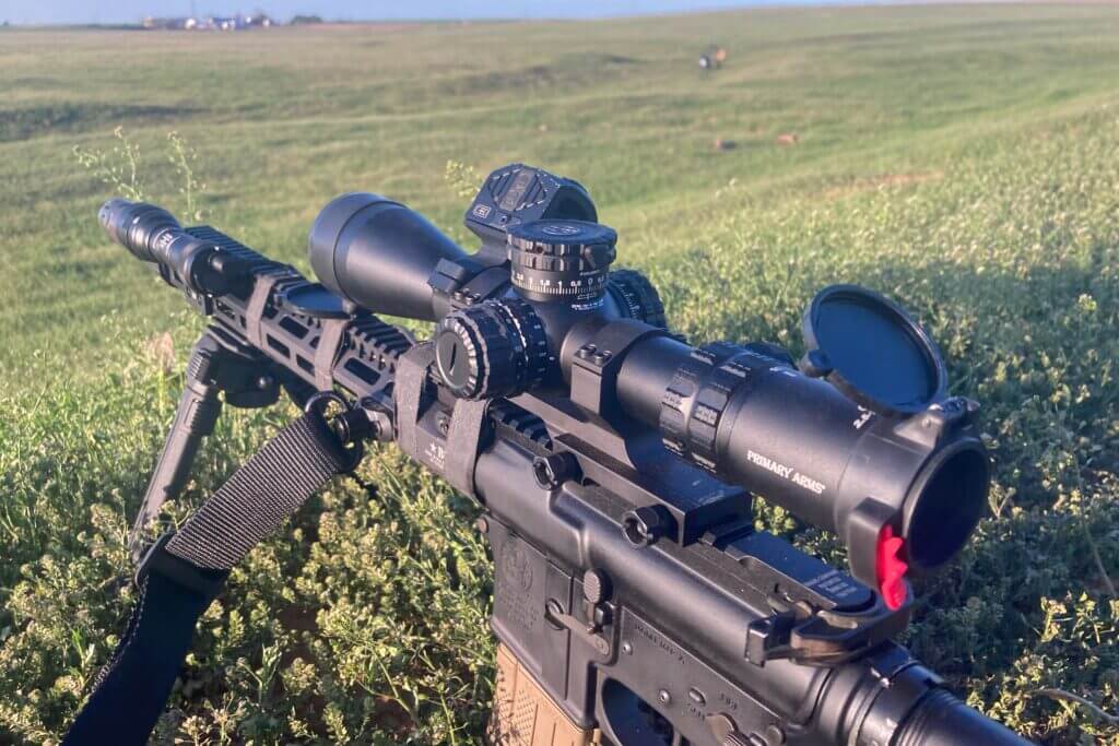 The Primary Arms GLX 2.5-10 mounted to a rifle in a field