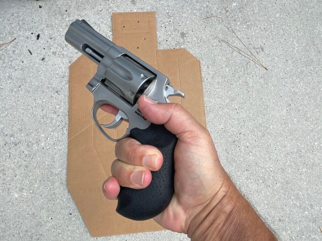 Revolver in hand next to cardboard target