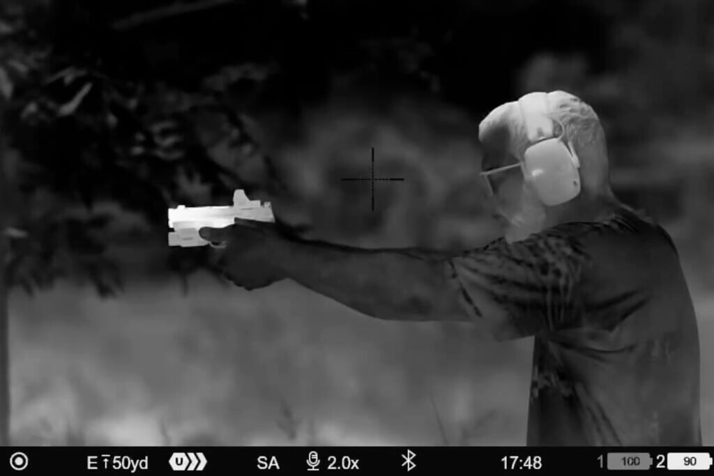 Thermal image of man shooting a handgun