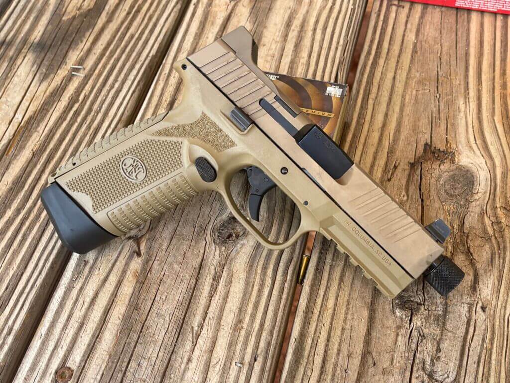 FN 545 handgun on wooden table