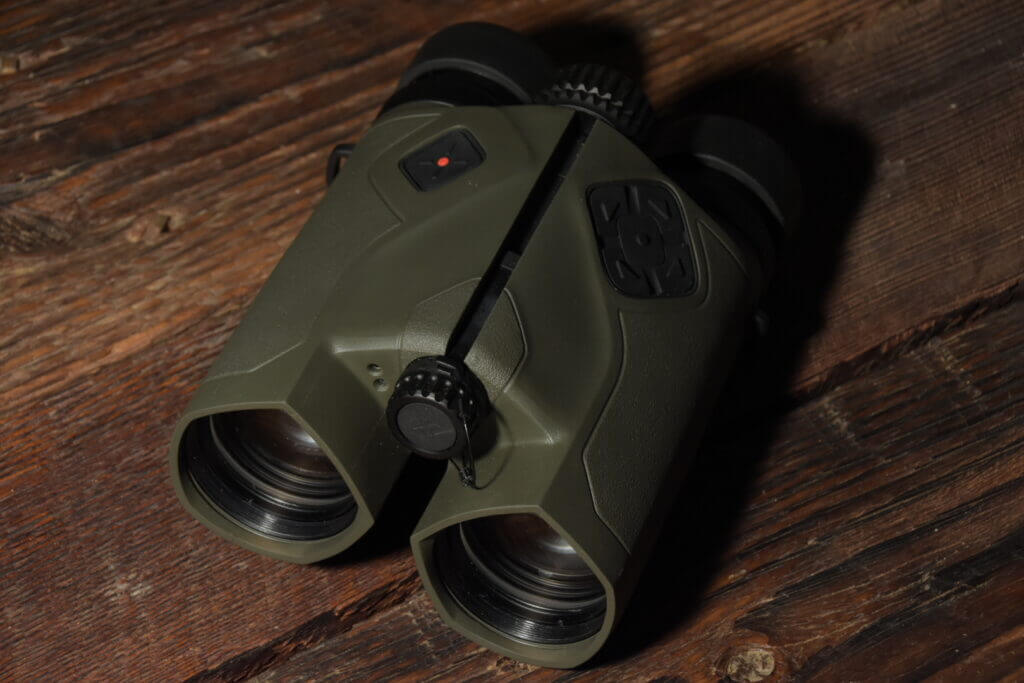 Vector X rangefinding binoculars staged on wooden background.
