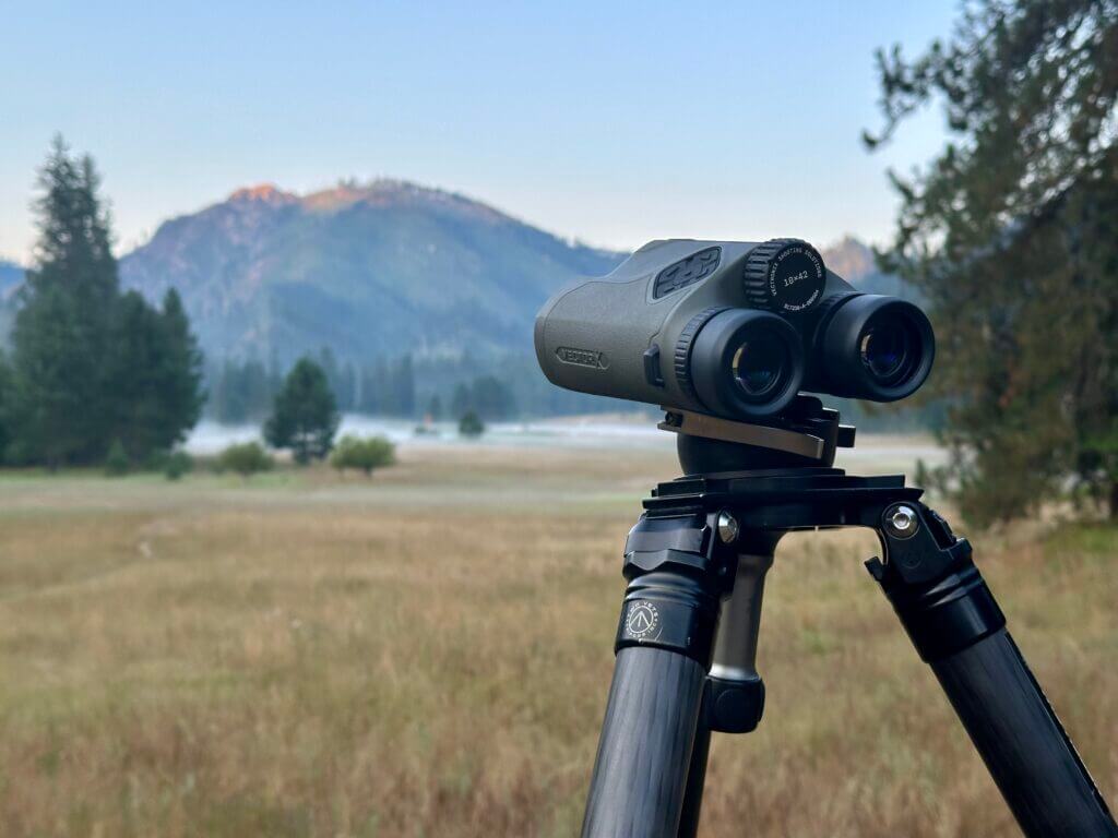 Binoculars on a tripod with the mountains in the background.