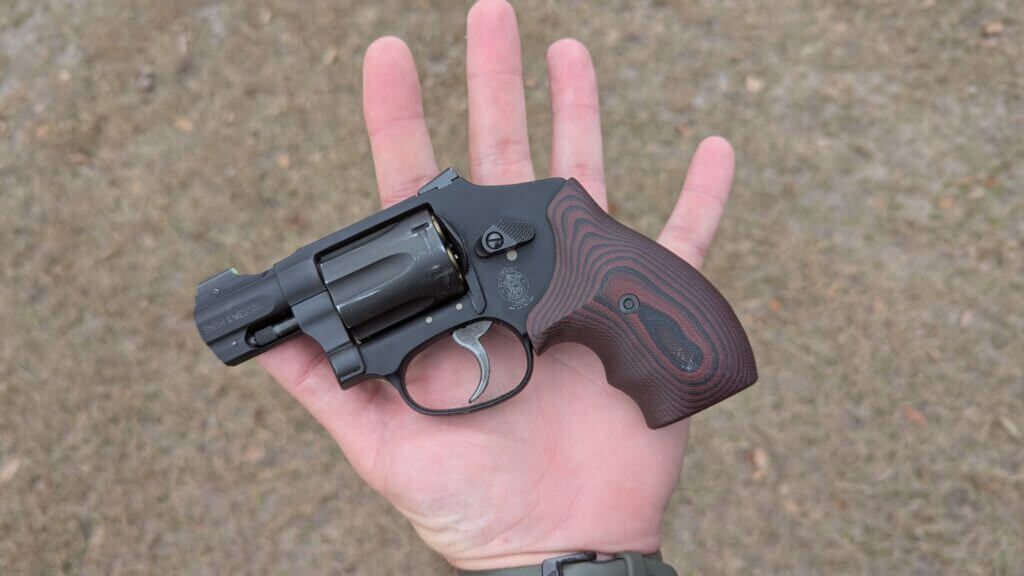 Compact concealed carry revolver in hand shows low profile round frame that prints less