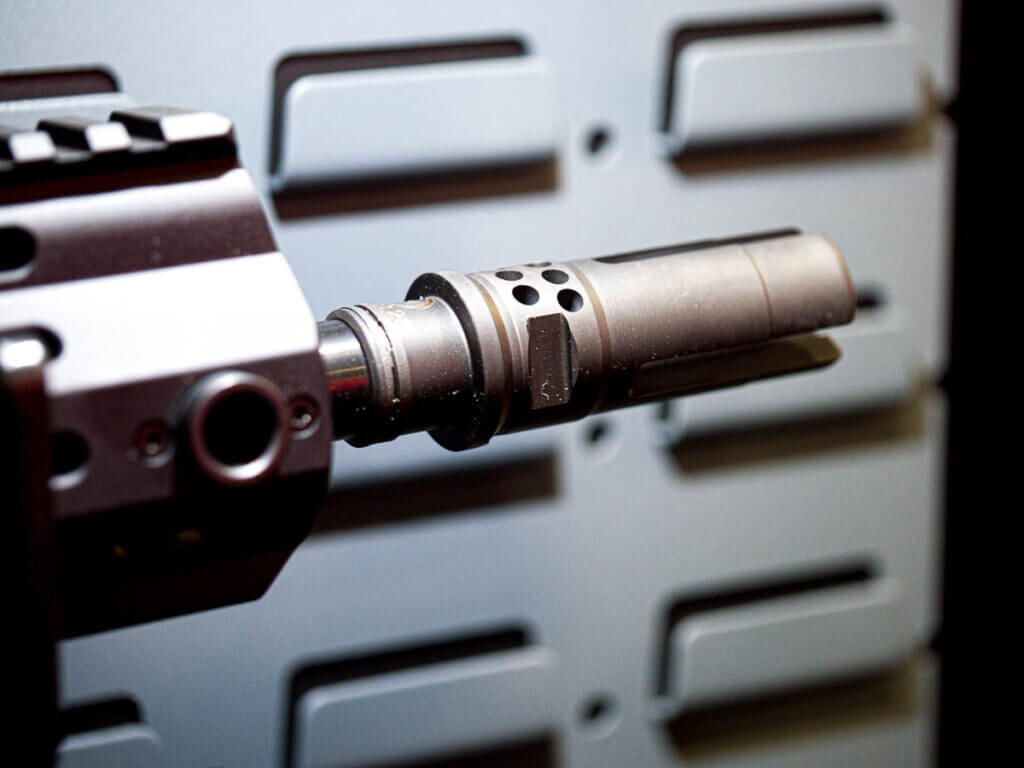close up of the muzzle device, a flash hider that is also a quick-connect device for the suppressor.