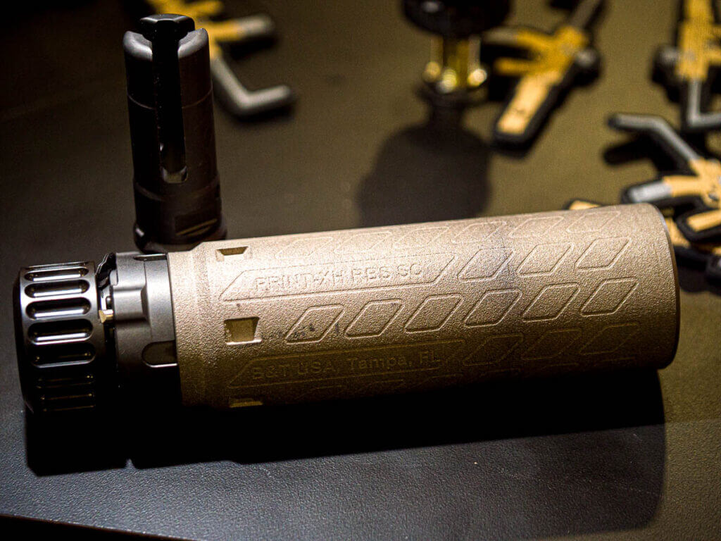 The print X suppressor laying on a table facing to the right.