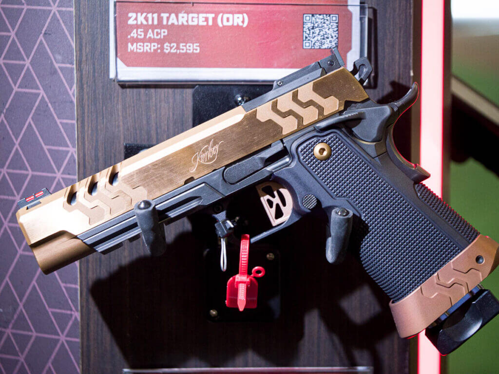 A golden gun sits on a wall mounted rack and points to the left. 