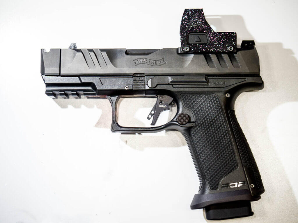 The gun is laying on a white table, facing to the left, the whole gun is visible.