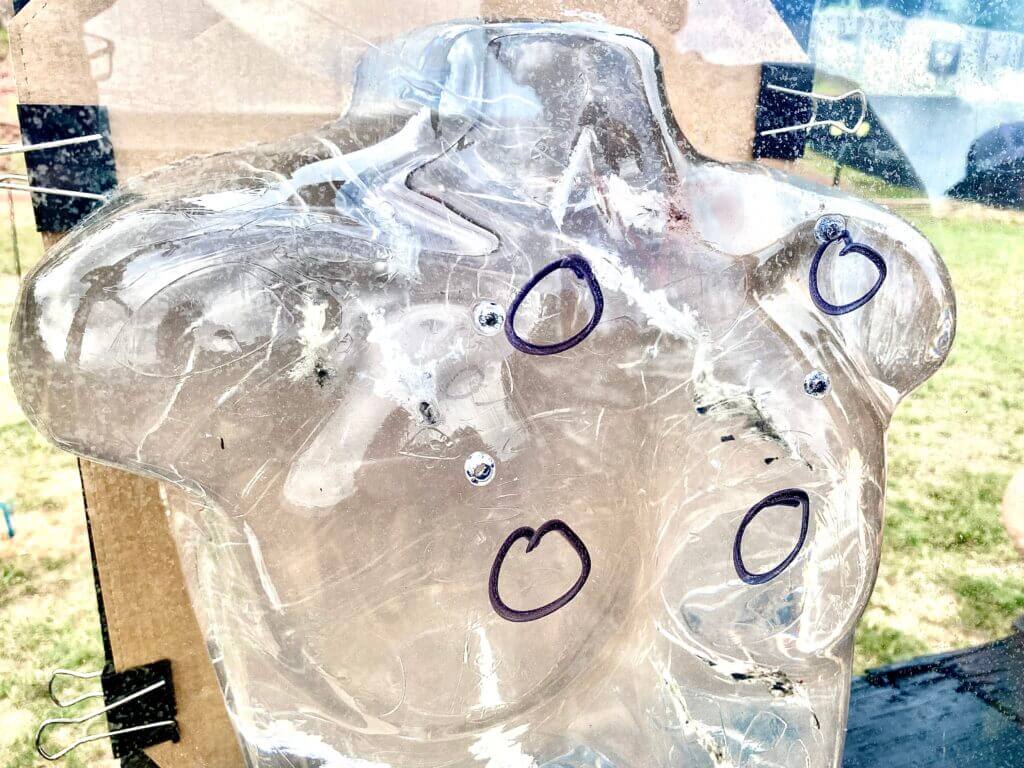 Torso shaped ballistic gel with circles drawn in marker to show where bullets penetrated